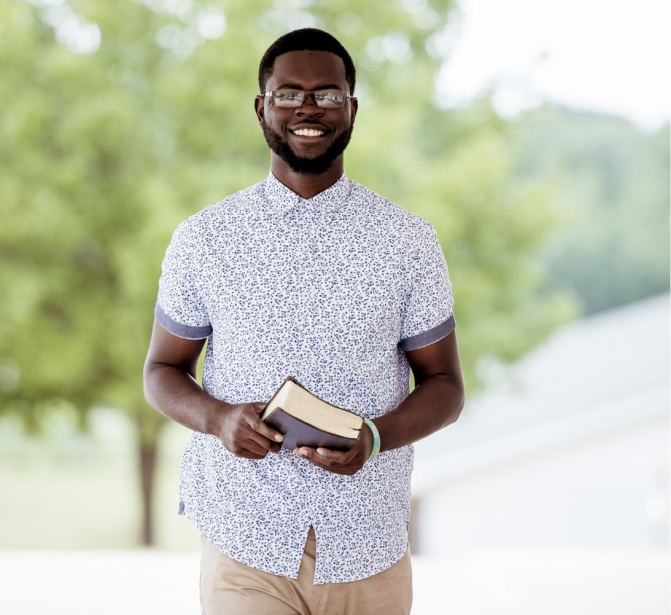 Smiling man holding a bible